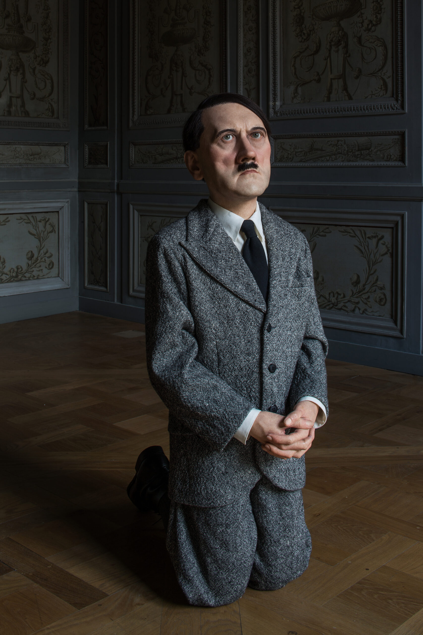 Maurizio Cattelan, Him, 2001, Wax, human hair, suit, and polyester resin, 101 x 41 x 53 cm, Installation view, Monnaie de Paris